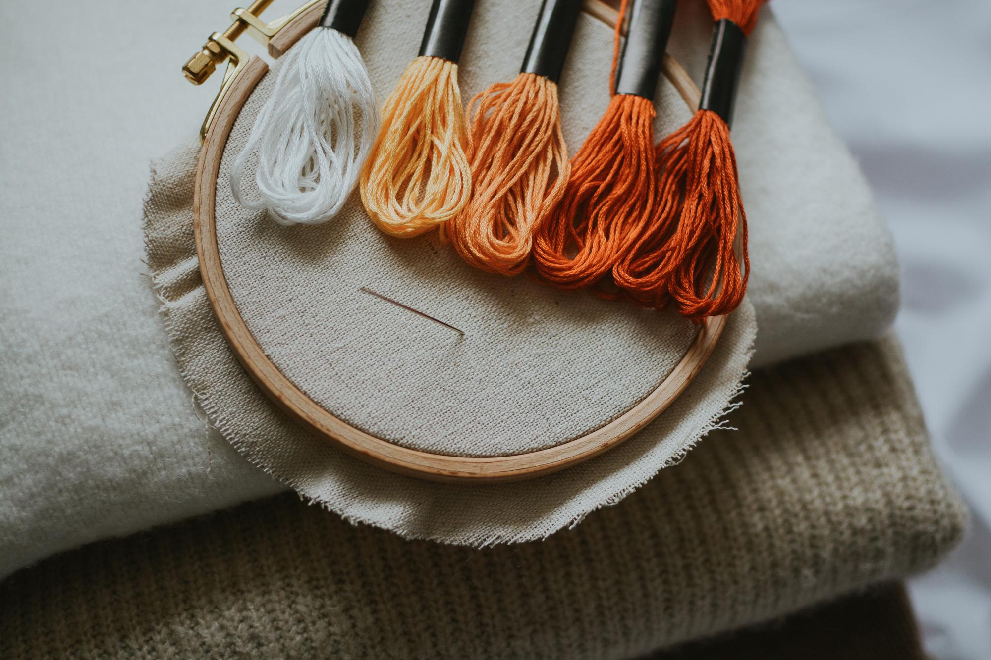 Close-up of hand embroidery on linen with warm tones